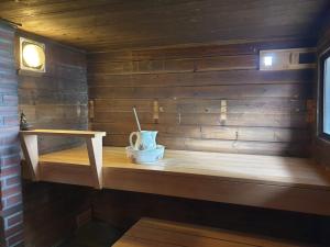 a sauna with a cup on a wooden shelf at Saunatie in Taipalsaari +39 photos