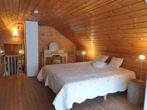a bedroom with a bed in a wooden room at Saunatie in Taipalsaari