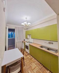 a kitchen with green cabinets and a white counter top at Tumo cozy corner in Yerevan
