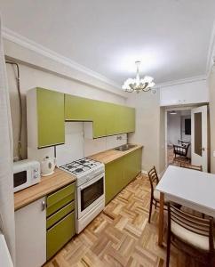 a kitchen with green cabinets and a table with chairs at Tumo cozy corner in Yerevan