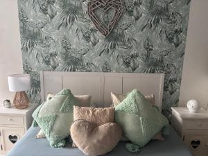 a bedroom with a bed with green pillows and a wallpaper at La Carola in Bordeaux-Saint-Clair