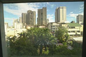 a city skyline with tall buildings and palm trees at Tom's Cabin Hotel in Cebu City +16 photos