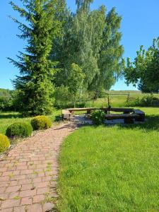 a brick path with a bench in the grass at Pod żurawiem II in Szwalk