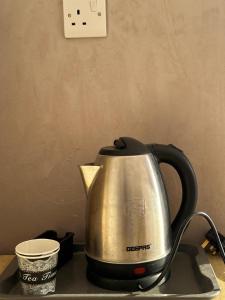 a tea kettle sitting on a table with a cup at MAJDOLINE Desert Camp in Wadi Rum
