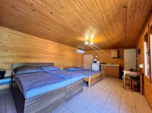 a bedroom with two beds and a wooden ceiling at Apartmány Harmónia in Veľký Meder