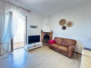 a living room with a leather couch and a fireplace at Casa del Riccio fronte mare in Mola di Bari