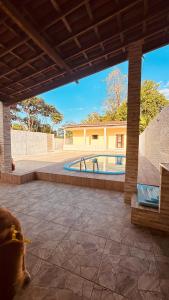a dog laying on a patio next to a swimming pool at Casa de veraneio jacuma in Conde