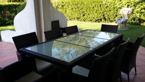 ポルト・レカナーティにあるRiviera del Coneroのガラスのテーブルと椅子が備わるパティオ