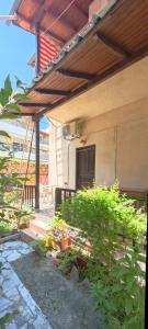 a patio with plants and a building with a roof at Revival rooms in Nikiana