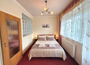 a bedroom with a bed and a large window at HoldLux Green Keyless 0-24 Apartman in Sárvár