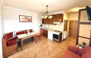 a kitchen and living room with a table and a couch at HoldLux Green Keyless 0-24 Apartman in Sárvár