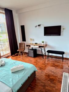 a bedroom with a bed and a table and a desk at SunRiviera Mamaia Nord in Mamaia Sat/Năvodari