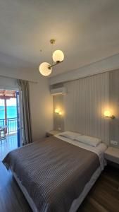 ein Schlafzimmer mit einem großen Bett und Wandleuchten in der Unterkunft Nostos in Patitiri