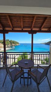 eine Terrasse mit Tisch und Stühlen und dem Meer in der Unterkunft Nostos in Patitiri