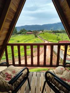 two chairs on a porch with a view of a field at Pousada Vista da Mantiqueira - Chalés Sabiá, Beija-Flor e Siriema in Extrema +18 photos
