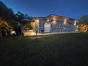 a stone house with lights on the front of it at KONSTANTINOS Luxury Living in Ofrínion