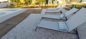 three white chairs sitting next to a swimming pool at Cantinho de Terena - Cheiros Da Terra in Terena