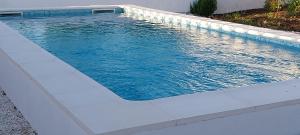 a swimming pool with blue water in a backyard at Cantinho de Terena - Cheiros Da Terra in Terena