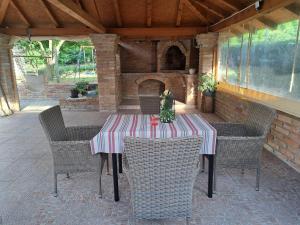 a table with chairs and a fireplace on a patio at Apartman Vučedolski san in Vukovar