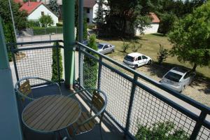 a balcony with a table and two parked cars at HoldLux Green Keyless 0-24 Apartman in Sárvár