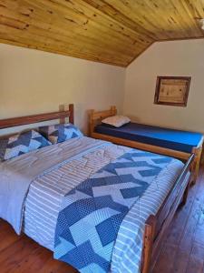 a bedroom with two beds and a wooden ceiling at Pousada Vista da Mantiqueira - Chalés Sabiá, Beija-Flor e Siriema in Extrema