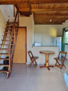 a room with a table and chairs and a staircase at Pousada Vista da Mantiqueira - Chalés Sabiá, Beija-Flor e Siriema in Extrema