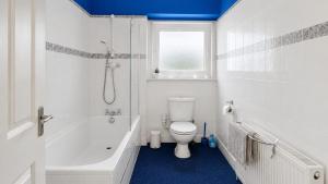 a white bathroom with a toilet and a shower at Ardyne House in Port Bannatyne +3 photos