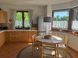 a kitchen with a table and chairs and a refrigerator at Landhaus mit Garten in Szczecin