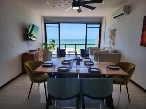 a dining table and chairs in a living room with the ocean at Apartment in Chixchulub with a spectacular view in Chicxulub