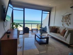 a living room with a couch and a table at Apartment in Chixchulub with a spectacular view in Chicxulub