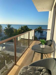 a balcony with a table and chairs and the ocean at Apartment in Chixchulub with a spectacular view in Chicxulub