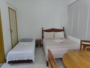 a small room with two beds and a table at Flat Alvorada in Ouro Preto