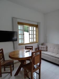 a living room with a wooden table and a couch at Flat Alvorada in Ouro Preto