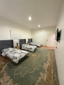 a room with three beds and a flat screen tv at دور سياحي in Abha