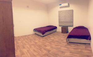a room with two beds and a wooden floor at دور سياحي in Abha +7 photos
