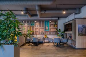 a restaurant with tables and chairs and plants at ibis Köln Frechen in Cologne