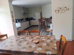 a dining room with a table and a kitchen at Gite de la haie portée in Lignieres-Orgeres