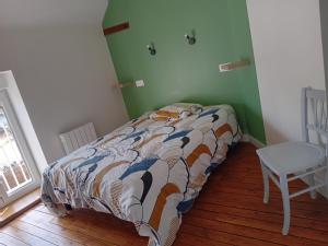 a bed in a room with a table and a chair at Gite de la haie portée in Lignieres-Orgeres
