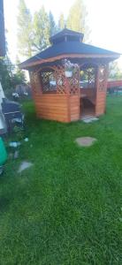 a wooden gazebo in the middle of a yard at Apartament u Bartosów in Czarny Dunajec +11 photos