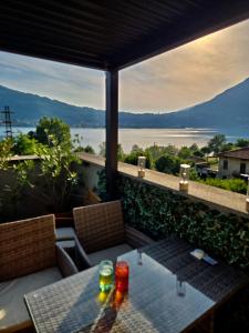 a table on a balcony with a view of the water at Felicita Cascata Terrace with Lake View in Lecco