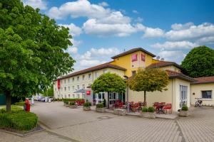 a building with tables and chairs in a courtyard at ibis Köln Frechen in Cologne