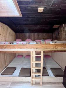 a room with four bunk beds and a wooden table at Bergunterkunft Ova Spin in Zernez
