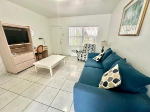 a living room with a blue couch and a tv at Birch Patio Motel in Fort Lauderdale