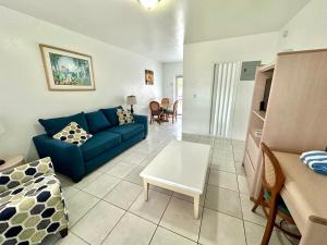 a living room with a blue couch and a table at Birch Patio Motel in Fort Lauderdale