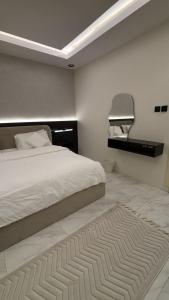 a bedroom with a bed and a rug on the floor at نزل سوم in Hail