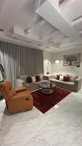 a living room with two couches and a red rug at نزل سوم in Hail