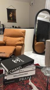 a stack of books in a living room with a couch at نزل سوم in Hail