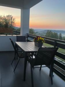 a table and chairs on a balcony with a sunset at Domek Na Wzgórzu Roztocze in Majdan Abramowski +97 photos