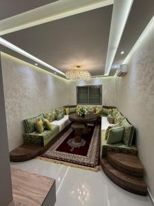 a living room with a couch and a table at Residence LINA in Bouznika