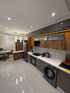 a large kitchen with a stove and a dishwasher at Residence LINA in Bouznika